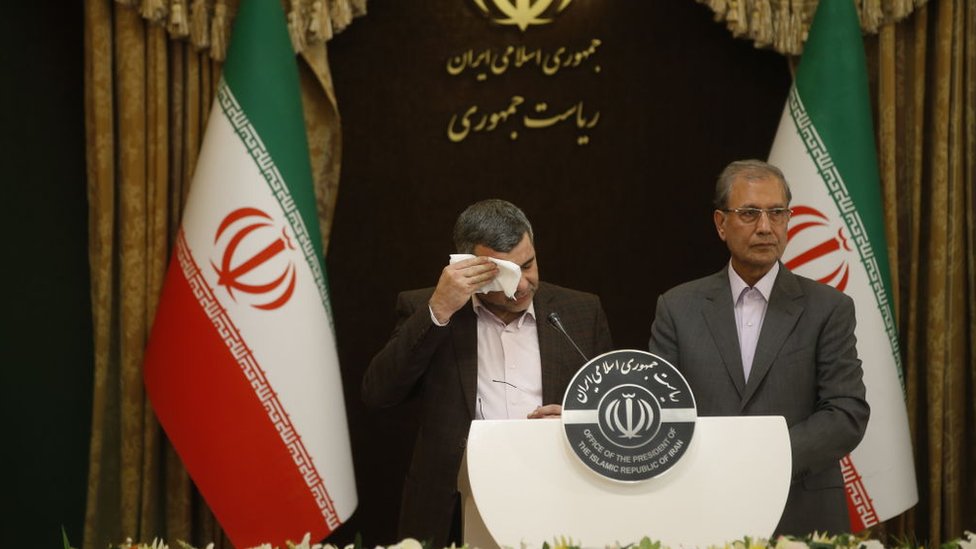 نائب وزير الصحة الإيراني إيرادج هريرتشي (يسار) وهو يجفف جبينه مرارا أثناء مؤتمر صحفي يوم الاثنين بعد أن أثبتت الفحوص إصابته بفيروس كورونا