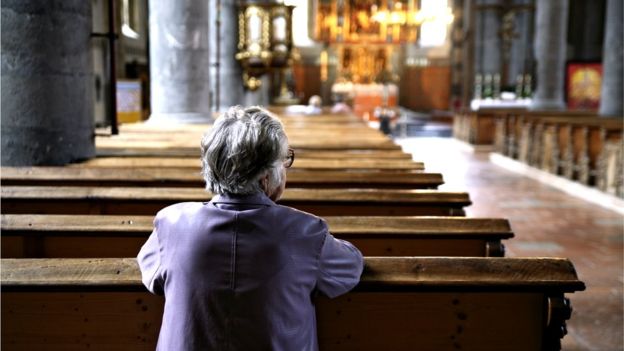إمرأة تجلس بمفردها في كنيسة