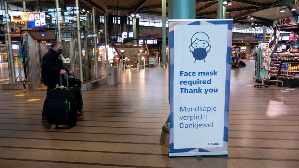 لافتة في أحد مراكز التسوق في هولندا تطالب الجمهور بارتداء الكمامة.
