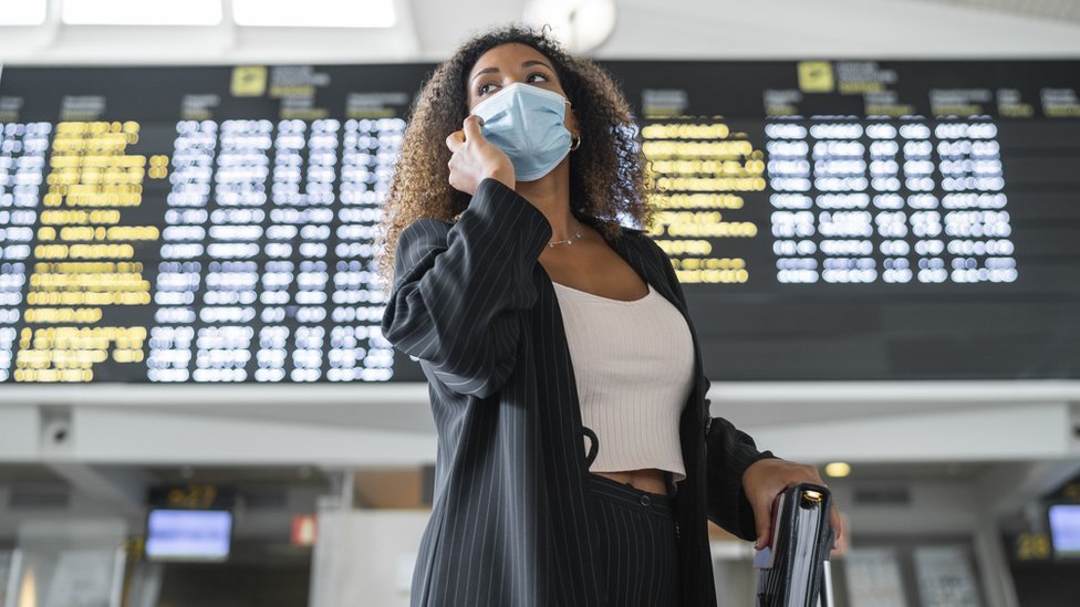 امرأة ترتدي قناع وجه في مطار