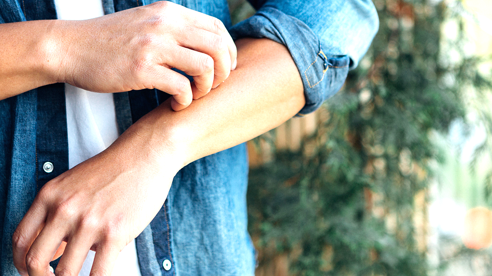 رجل يعاني من حكة في جلد ذراعه