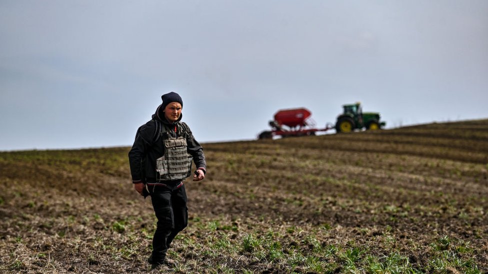 مزارع يرتدي سترة واقية من الرصاص أثناء البذر الربيعي في منطقة زابوريزهزهيا ، جنوب شرق أوكرانيا