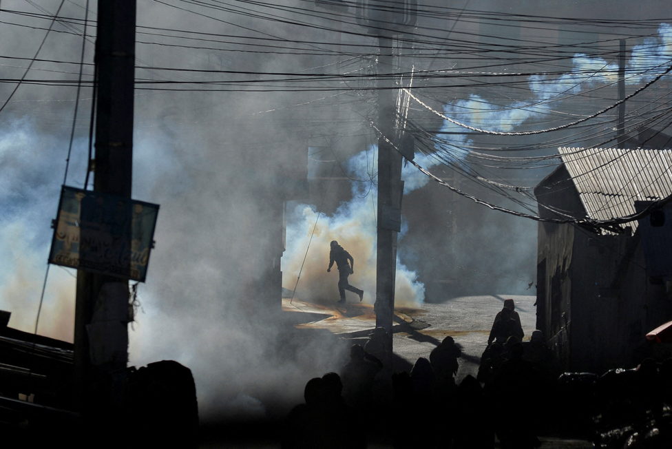 متظاهرون يجرون وسط الغاز المسيل للدموع في لاباز عاصمة بوليفيا، خلال اشتباكات مع الشرطة حول سوق كوكا جديد مثير للجدل يريد مزارعو الكوكا إغلاقه لأنهم يعتبرونه غير قانوني ، في لاباز ، بوليفيا ، 3 أغسطس/آب 2022.