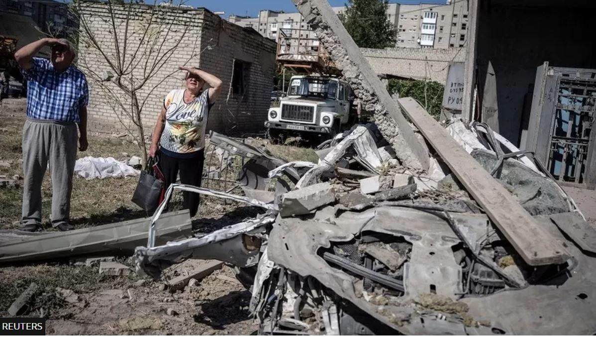 مواطنان أوكرانيان يقفان خارج مبنى للشقق السكنية دمرته ضربة صاروخية روسية في بوكروفسك بمنطقة دونيتسك